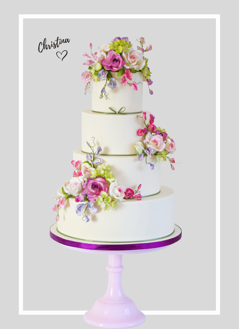 4 tier floral wedding cake adorned with pink and purple sugar flowers